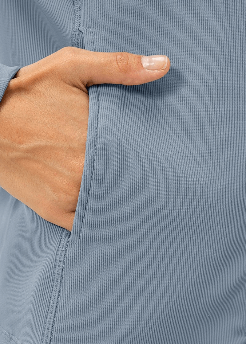 Close-up of a hand in a pocket of the Sports Insulated Women's Jacket with fleece lining, highlighting the fabric texture and stitching.